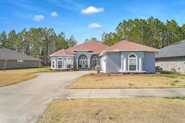 mediterranean / spanish-style home with a front yard