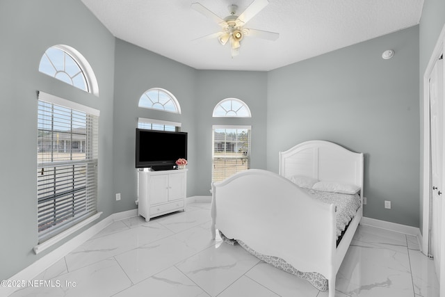 bedroom featuring ceiling fan and a textured ceiling