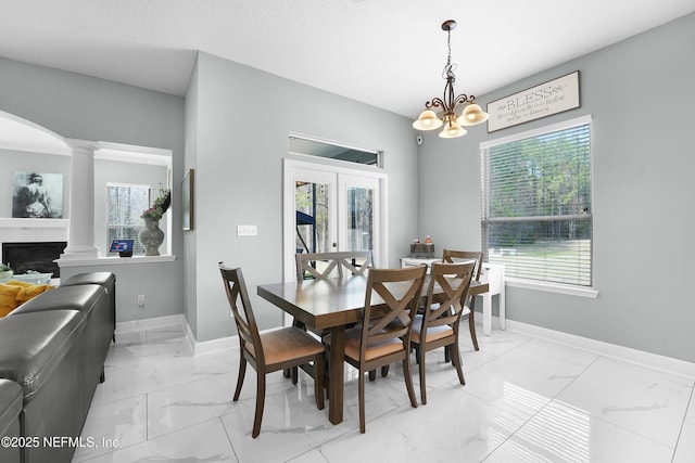 dining room with decorative columns, french doors, and a chandelier