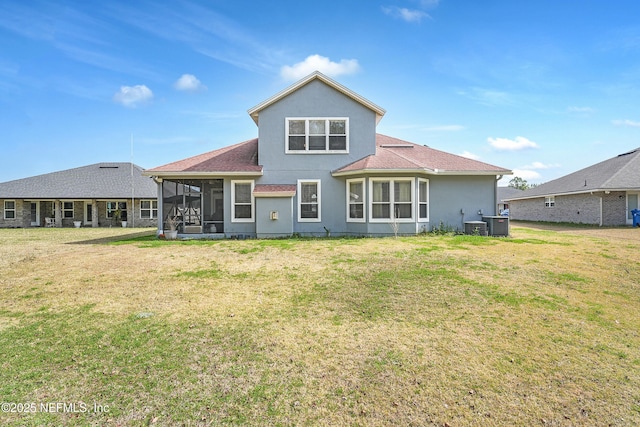 back of house featuring a lawn and a sunroom