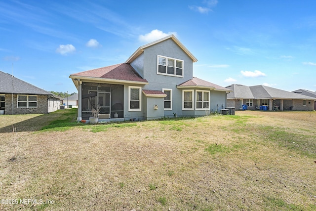 rear view of house featuring a yard, central AC unit, and a sunroom