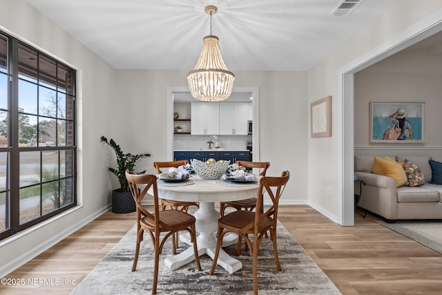 dining area with a chandelier and light wood-type flooring