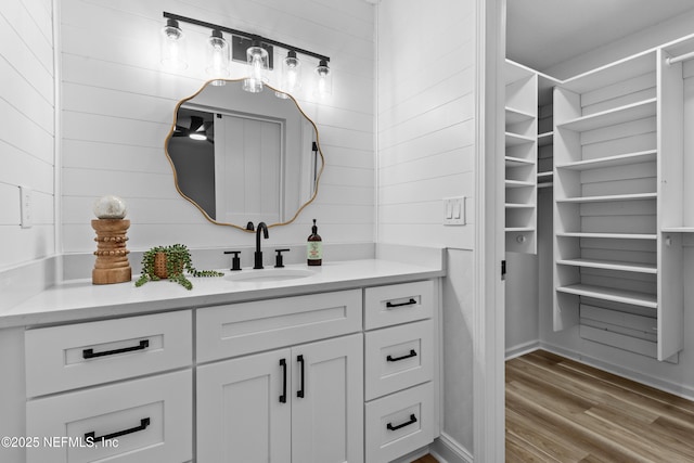 bathroom featuring vanity, hardwood / wood-style flooring, and wood walls