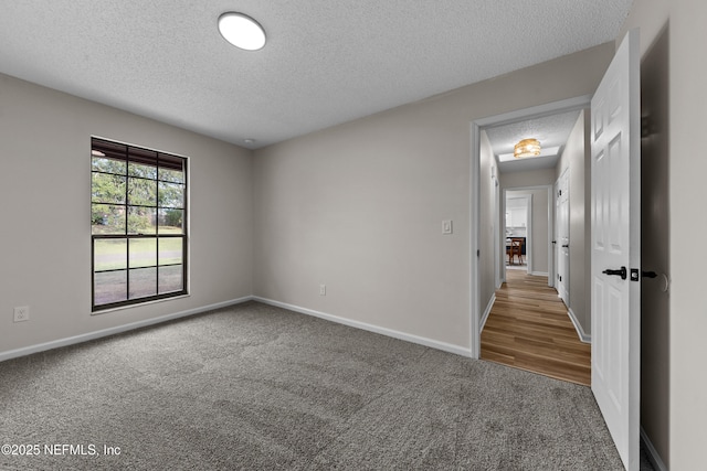 carpeted empty room with a textured ceiling