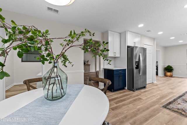 dining space featuring a textured ceiling and light hardwood / wood-style floors