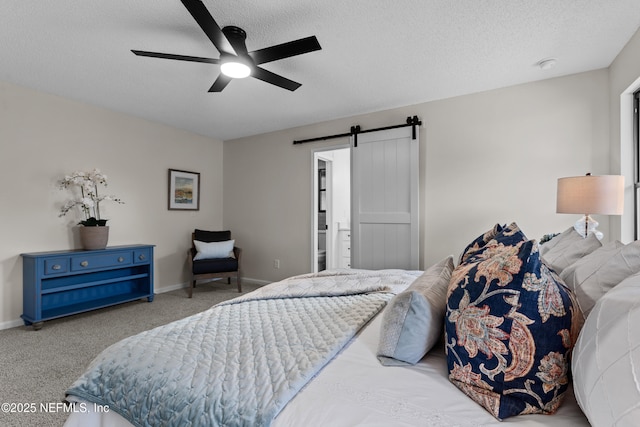 carpeted bedroom with ceiling fan, a barn door, and a textured ceiling