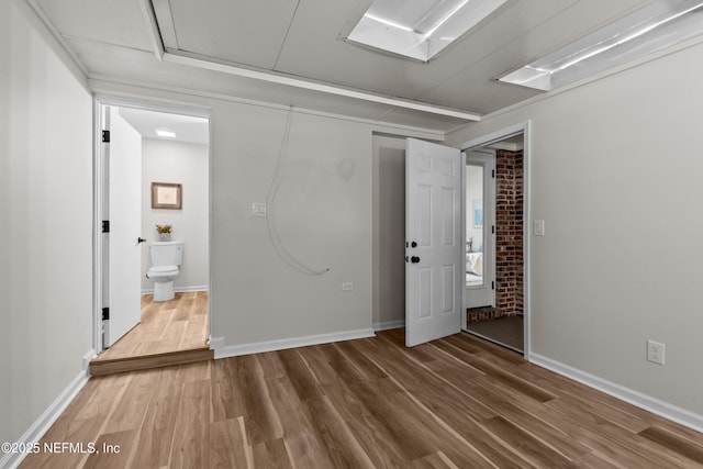 unfurnished bedroom featuring hardwood / wood-style flooring, a closet, and ensuite bathroom