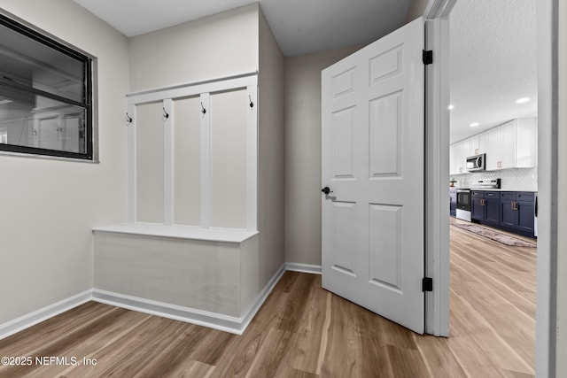 mudroom featuring a textured ceiling and light wood-type flooring