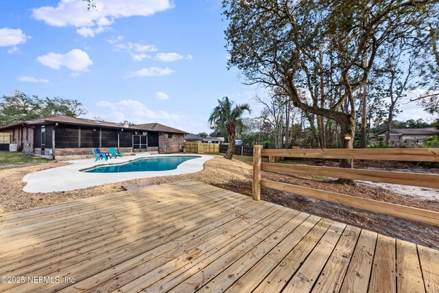 view of swimming pool with a sunroom, a deck, and a patio area