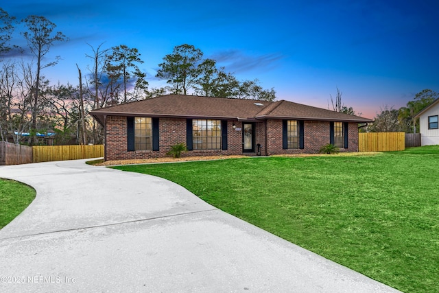 ranch-style home featuring a lawn