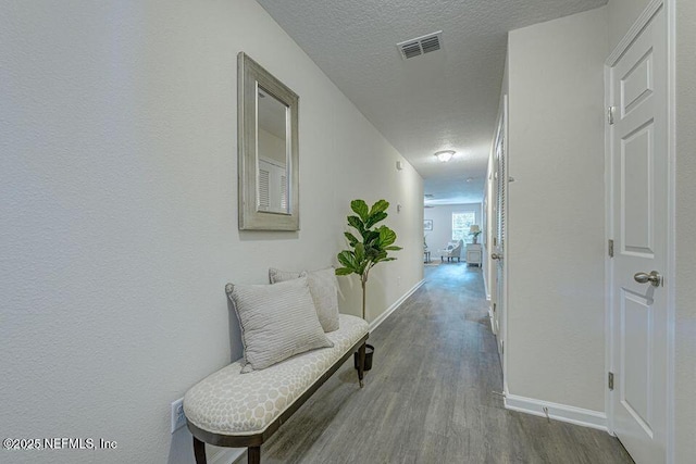 hallway with wood-type flooring and a textured ceiling