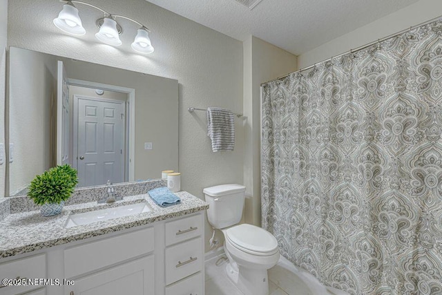 bathroom featuring vanity, tile patterned floors, toilet, and a textured ceiling