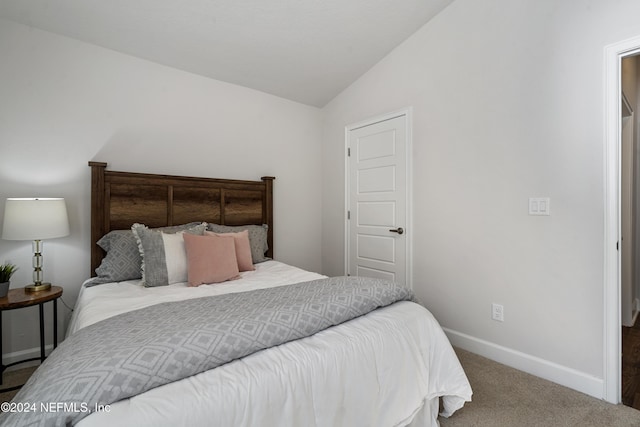 carpeted bedroom with lofted ceiling