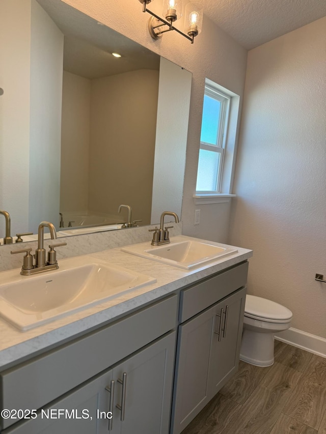 8284 Helmsley Blvd, Jacksonville, FL 32219 - full bathroom with a sink, toilet, wood finished floors, and double vanity