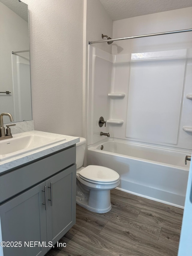 8284 Helmsley Blvd, Jacksonville, FL 32219 - full bath featuring toilet, vanity, wood finished floors, a textured ceiling, and  shower combination