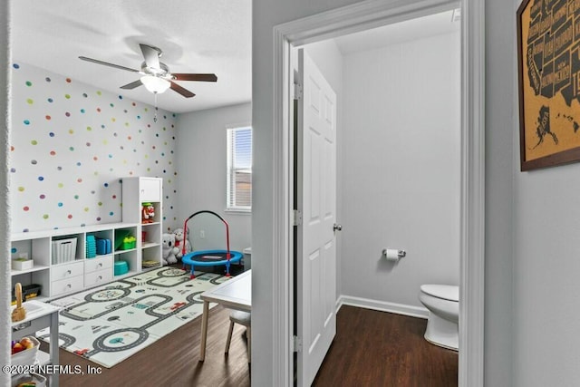 recreation room featuring dark hardwood / wood-style floors and ceiling fan