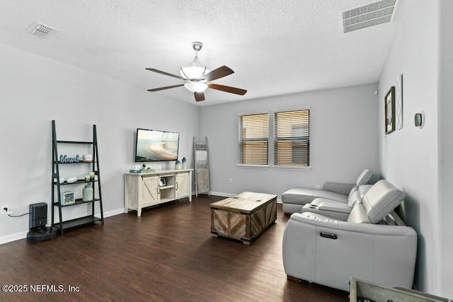 living room featuring dark hardwood / wood-style flooring, a textured ceiling, and ceiling fan