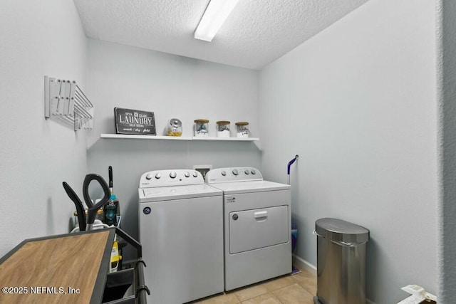 laundry area featuring independent washer and dryer, a textured ceiling, and light tile patterned floors