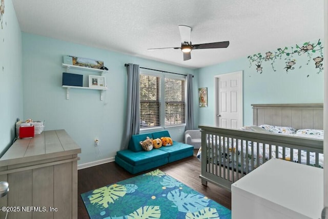 bedroom with ceiling fan, dark hardwood / wood-style flooring, and a textured ceiling