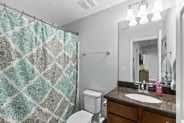 bathroom with vanity, toilet, and a textured ceiling