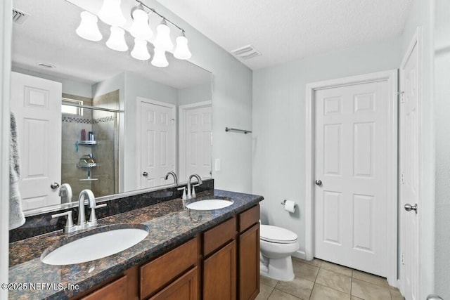 bathroom featuring vanity, tile patterned floors, toilet, and walk in shower