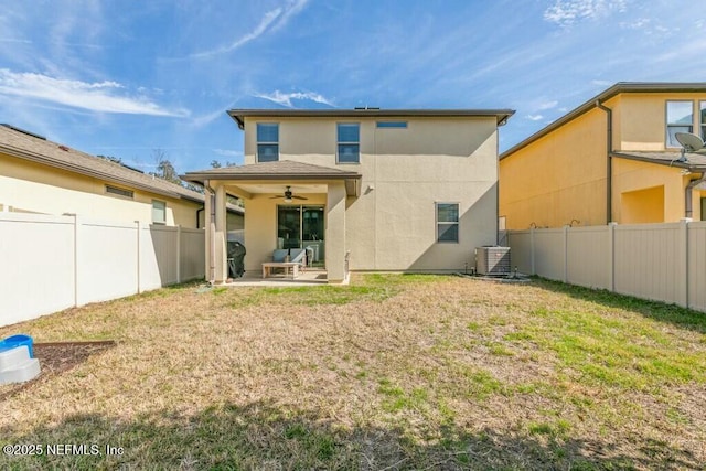 back of property with a patio, central AC unit, ceiling fan, and a lawn