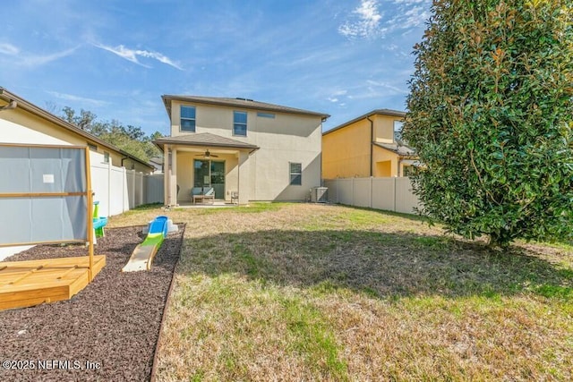 back of property featuring a yard and ceiling fan