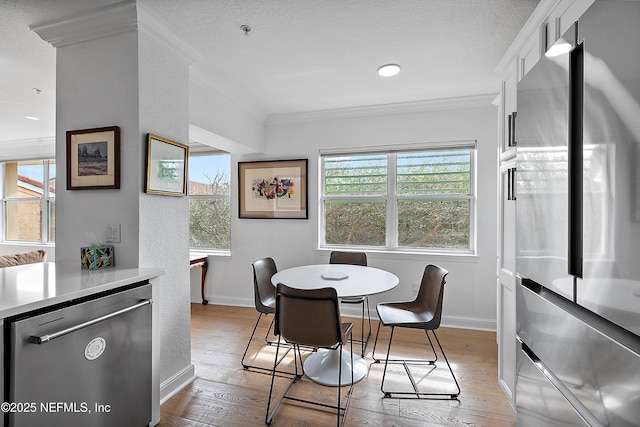 dining area with crown molding, a textured ceiling, and light hardwood / wood-style flooring