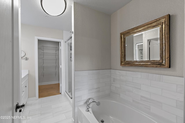 bathroom with vanity and shower with separate bathtub