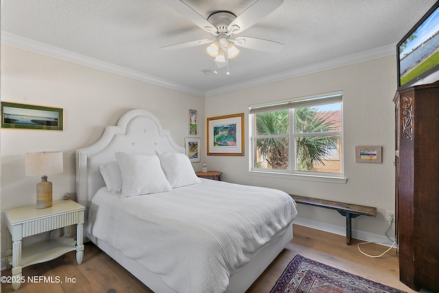 bedroom featuring hardwood / wood-style floors, ornamental molding, and a textured ceiling