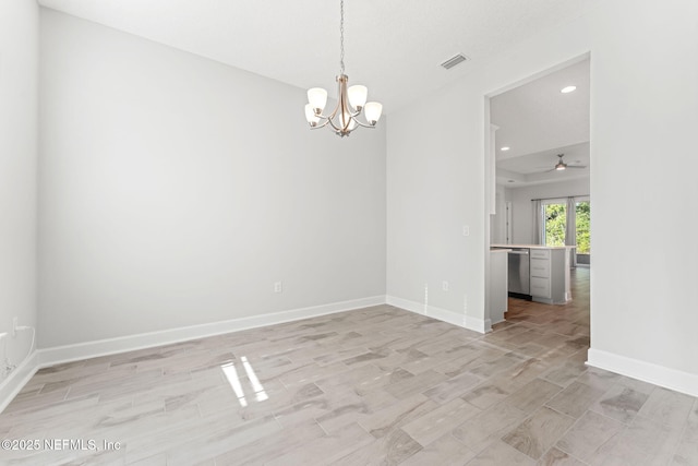 empty room featuring an inviting chandelier and light hardwood / wood-style floors