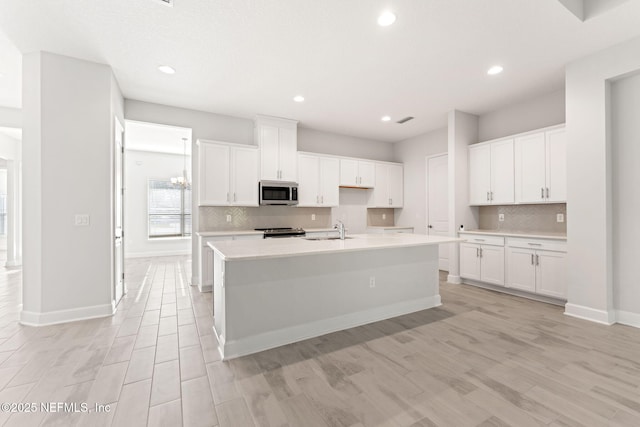 kitchen featuring white cabinetry, sink, an island with sink, and appliances with stainless steel finishes