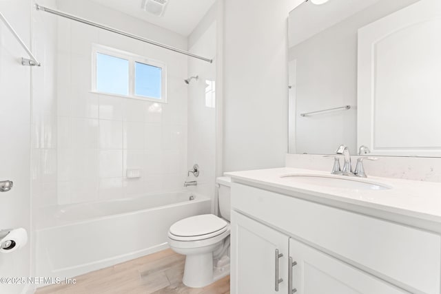 full bathroom featuring vanity, hardwood / wood-style floors, toilet, and tiled shower / bath