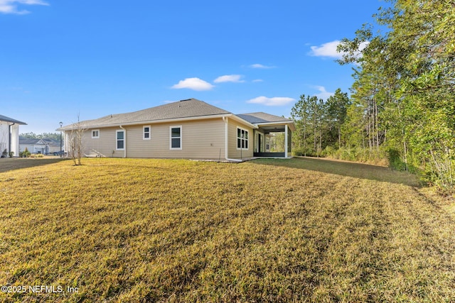 rear view of property with a lawn