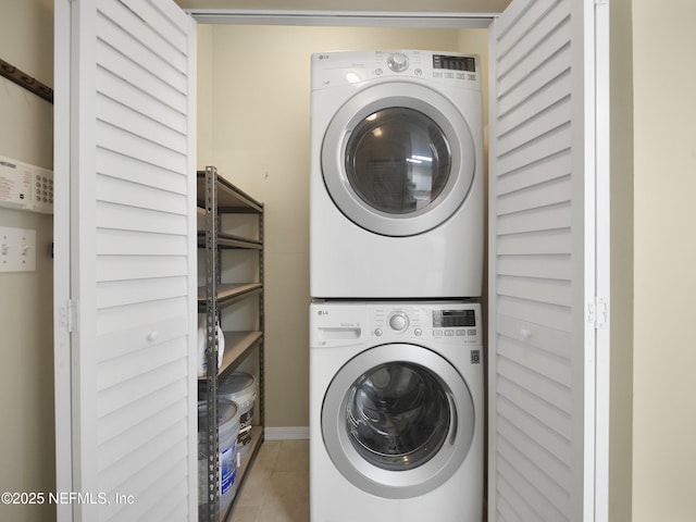 laundry area with laundry area, tile patterned floors, and stacked washer / drying machine