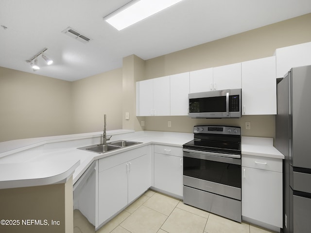 kitchen with a sink, visible vents, white cabinetry, light countertops, and appliances with stainless steel finishes