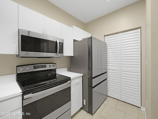 kitchen featuring light tile patterned floors, light countertops, appliances with stainless steel finishes, and white cabinets