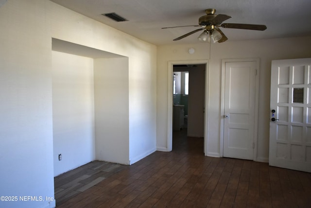 empty room with dark wood-type flooring and ceiling fan