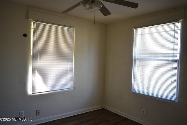 empty room featuring a healthy amount of sunlight, dark wood-type flooring, and ceiling fan