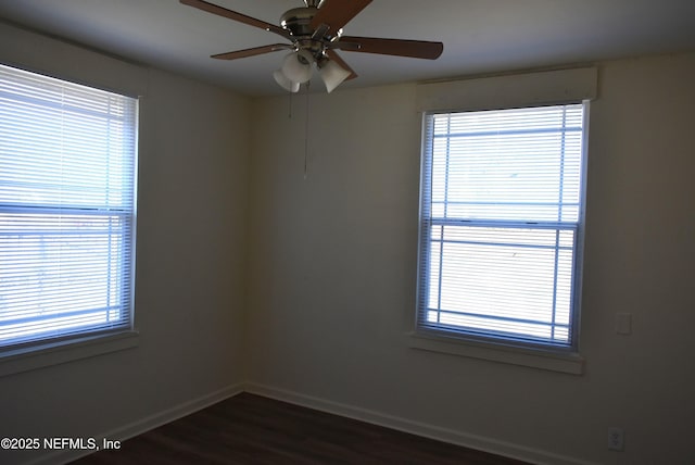 spare room with dark hardwood / wood-style flooring and ceiling fan