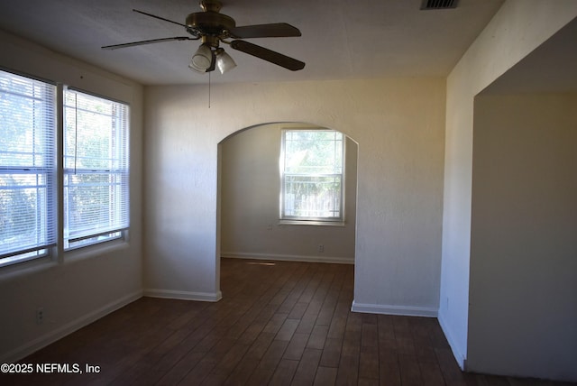 unfurnished room with dark wood-type flooring, a wealth of natural light, and ceiling fan