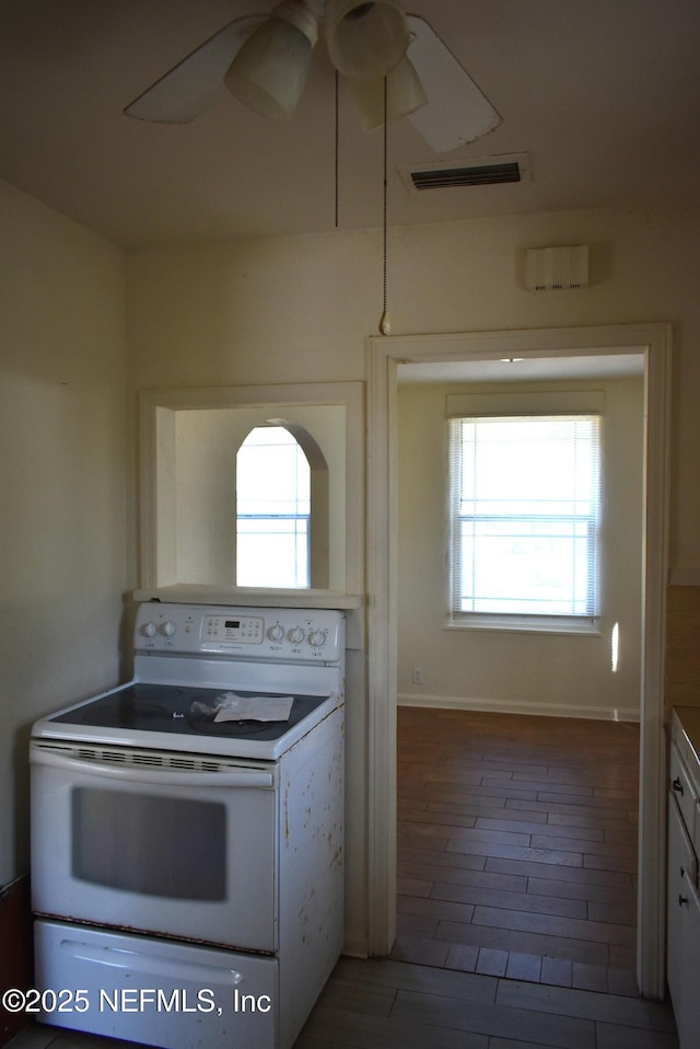 kitchen featuring a healthy amount of sunlight, electric range, and ceiling fan