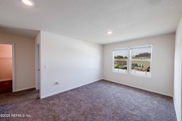 carpeted spare room featuring a textured ceiling