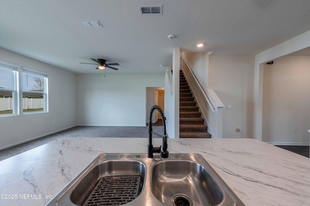 kitchen featuring ceiling fan, sink, and a textured ceiling