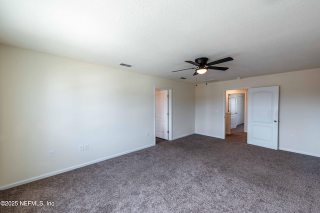 unfurnished bedroom with ceiling fan, dark carpet, and a textured ceiling