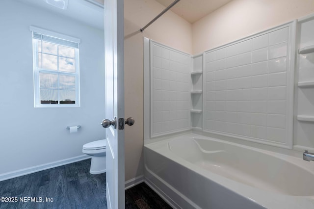 bathroom featuring toilet, hardwood / wood-style floors, and shower / bathing tub combination