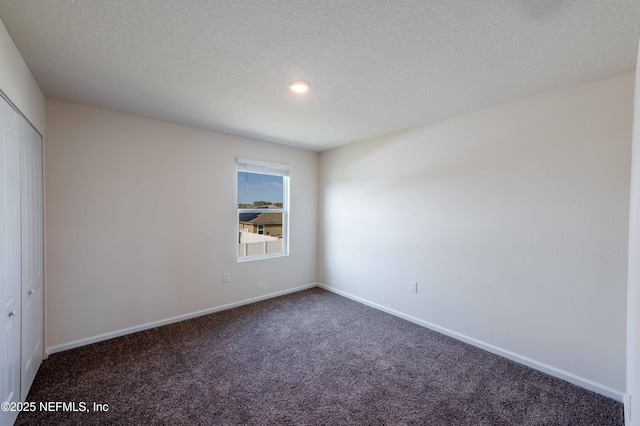 spare room with carpet flooring and a textured ceiling