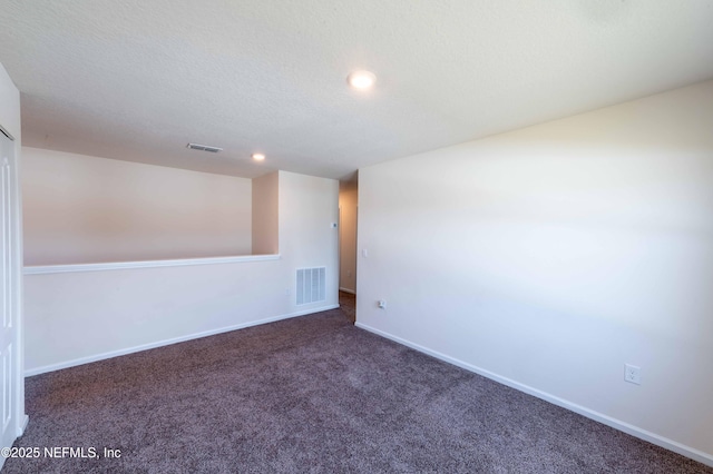 carpeted empty room with a textured ceiling