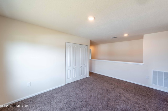 carpeted empty room with a textured ceiling