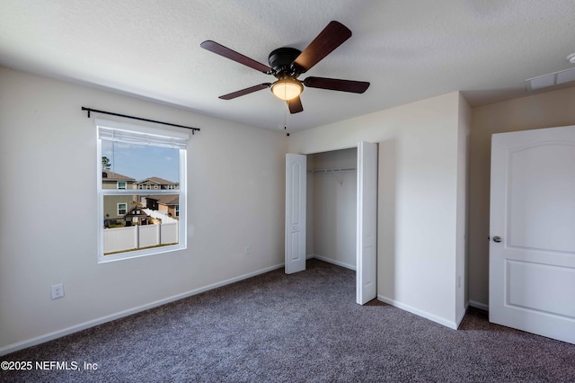 unfurnished bedroom featuring a closet, a textured ceiling, and dark colored carpet